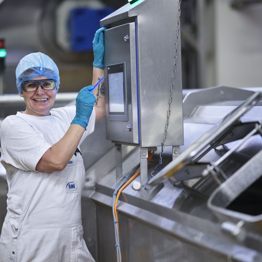BMi Mitarbeiterin bedient Maschine